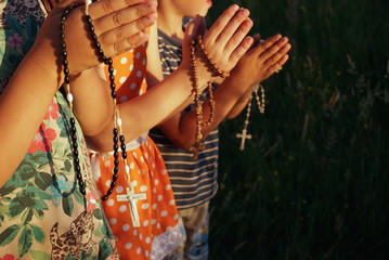 children pray on rosaries