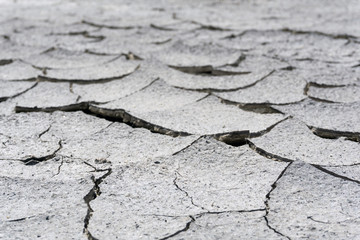 background - cracked dry sun-dried clay crust in a waterless desert