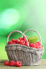 Fototapeta na wymiar Ripe raspberries in basket on wooden table