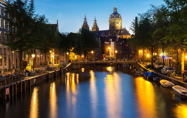 Night red-light district De Wallen, canal, Basilica of Saint Nicholas and bridge, Amsterdam, Holland. Long exposure.