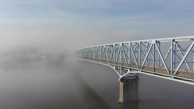 A slow forward aerial establishing shot of a bridge over the Ohio River on a foggy morning. Pittsburgh suburbs.  	
