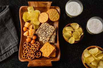 Lager beer and snacks on stone table. Nuts, chips. Top view with copyspace