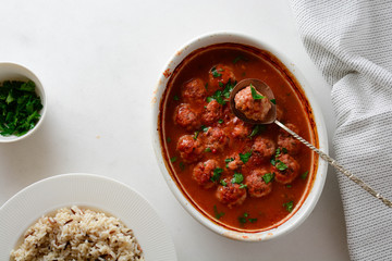 Traditional spicy meatballs in tomato sauce with garnish on a concrete background. Selective focus.