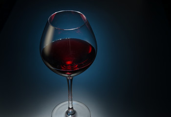 Red wine in a glass on dark blue background