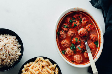 Traditional spicy meatballs in tomato sauce with garnish on a concrete background. Selective focus.