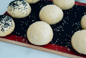 Round bun, sesame bun, bread rolls. Tasty burger bread with sesame on wooden. Freshly baked hamburger buns.