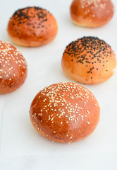 Round bun, sesame bun, bread rolls. Tasty burger bread with sesame on wooden. Freshly baked hamburger buns.