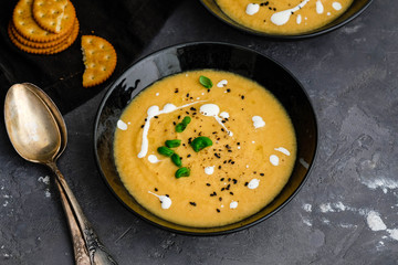 Carrot, ginger, turmeric soup in a bowl on marble background. Empty space for text.