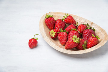 Tasty ripe strawberry on white wooden table