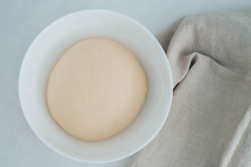 Raw yeast dough in a bowl. Country style, selective focus