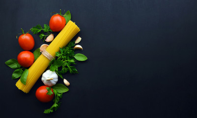 Ingredients for spaghetti with tomato sauce on dark wooden background. Italian healthy food background. Flat- lay.