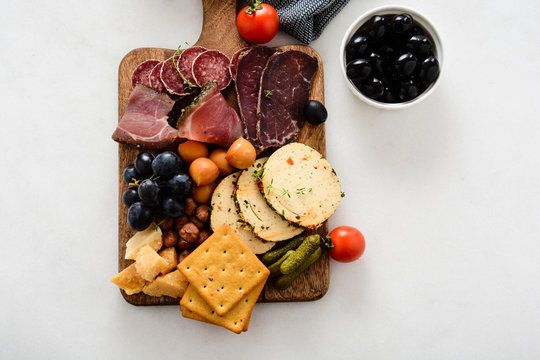 Table full of mediterranean appetizers, tapas or antipasto. Assorted Italian food set. Delicious snack on party or picnic time. Chopping board with meat and cheese. Italian style banquet. Top view.
