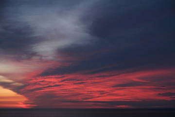 Zachód słońca nad morzem z czerwonymi chmurami - obrazy, fototapety, plakaty