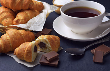 Fresh croissants and a cup of hot tea / coffee. Breakfast. Homemade croissants with chocolate.