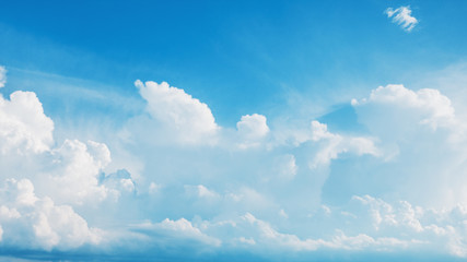 White fluffy cumulus clouds flying, fast moving blue sky at cloudy summer day