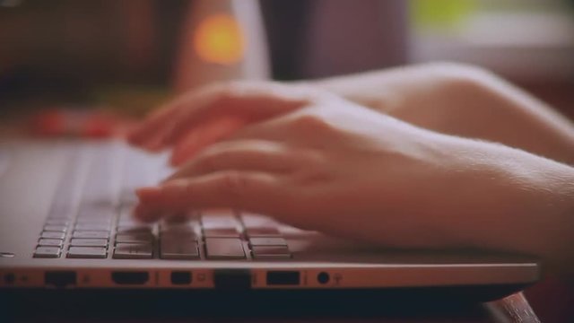hands of a young woman. using laptop, typing text.