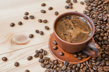 A cup of coffee and coffee beans on a wooden table