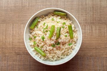 Bowl with brown rice and green beans on table