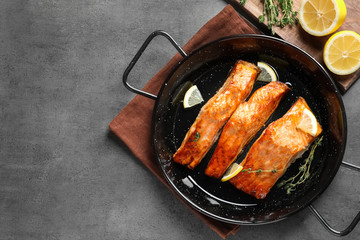 Dish with tasty cooked salmon on table, top view