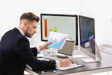 Male broker working in office. Finance trading concept