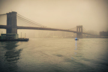 Fototapeta na wymiar Brooklyn bridge at foggy rainy evening, New York City