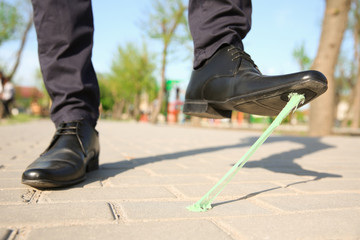 Man stepping in chewing gum on sidewalk. Concept of stickiness