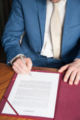 sign contract / the manager signs the official contract on the parties' agreement
