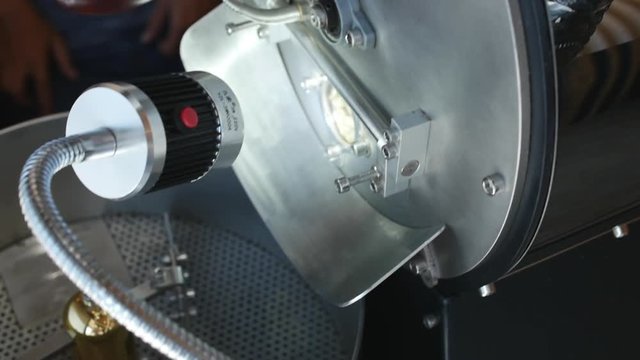 Coffee raw grains are fried in a professional coffeemachine to make a real coffee. Professional coffee maker for roasting coffee beans.