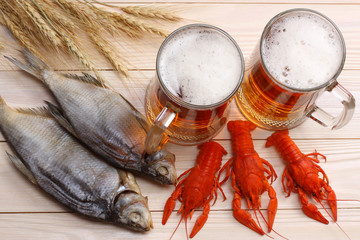 Glass beer with crawfish and dried fish on light wooden background. Beer brewery concept. Beer background. top view
