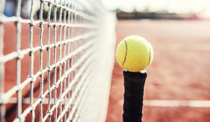 Tennis ball with racket on the tennis court. Sport, recreation concept