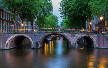 Fototapeta na wymiar Night city view of Amsterdam canals and seven bridges, Holland.