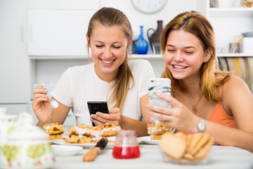 Obraz na płótnie Canvas females chatting on phone and drinking tea