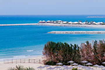 Beautiful blue sea and beach resort huts from al hamra beach view