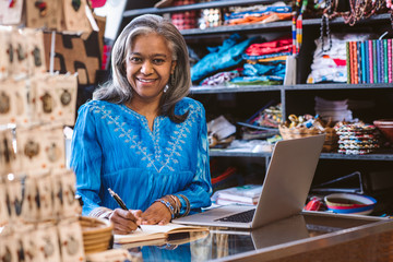 Smiling woman working at the counter of her fabric shop
