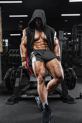 Naklejka na ściany i meble Handsome young fit muscular caucasian man of model appearance workout training in the gym gaining weight pumping up muscle and poses fitness and bodybuilding sport nutrition concept
