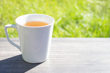 A cup of tea on the wooden table in the early morning