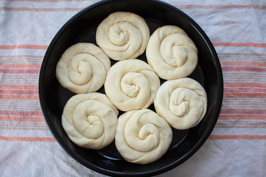 Raw twisted dough with stuffing rises in the roaster. Traditional moldavian food called platzinda