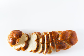 cut braided bread sprinkled with poppy seeds, isolated on white. copy space
