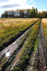 Obraz premium Dirty road in the meadow after a rain