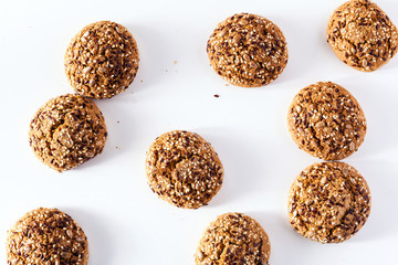 freshly baked oatmeal cookies sprinkled with sunflower seeds, linseed and sesame seeds. healthy pastries on a white background