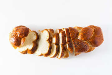 cut braided bread sprinkled with poppy seeds, isolated on white. copy space