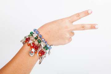Woman's hand wearing jewelry accessory bracelets in neutral background