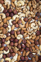 Mixed nuts (cashew, hazelnuts, walnuts, almonds) on white wooden background, top view. From above.