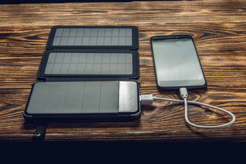 external battery with solar panel is charges mobile phone