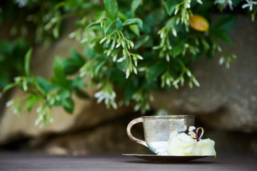 In silence cocktail on wooden table background. Metal cup of alcohol cocktail with cognac and spices, close-up