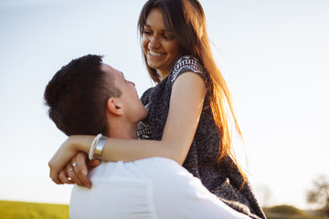 young, happy, loving couple, outdoors, man holding a girl in his arms , and enjoying each other, advertising, and inserting text