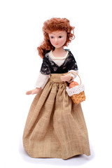 Porcelain doll in vintage clothes with a basket
