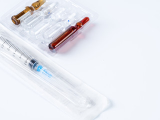 Syringe and packing ampoules on white table