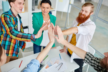 Group young business colleagues giving high five after success work