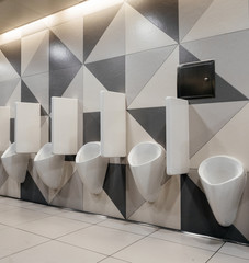 Interior of modern men toilet with row of urinals